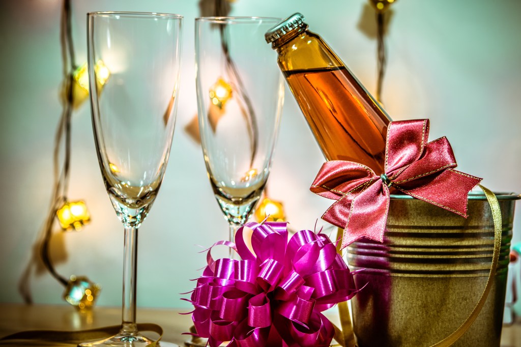Champagne and refrigerated glass ready to celebrate -with a candle lit in a candlestick for Christmas and New Year's Festival.